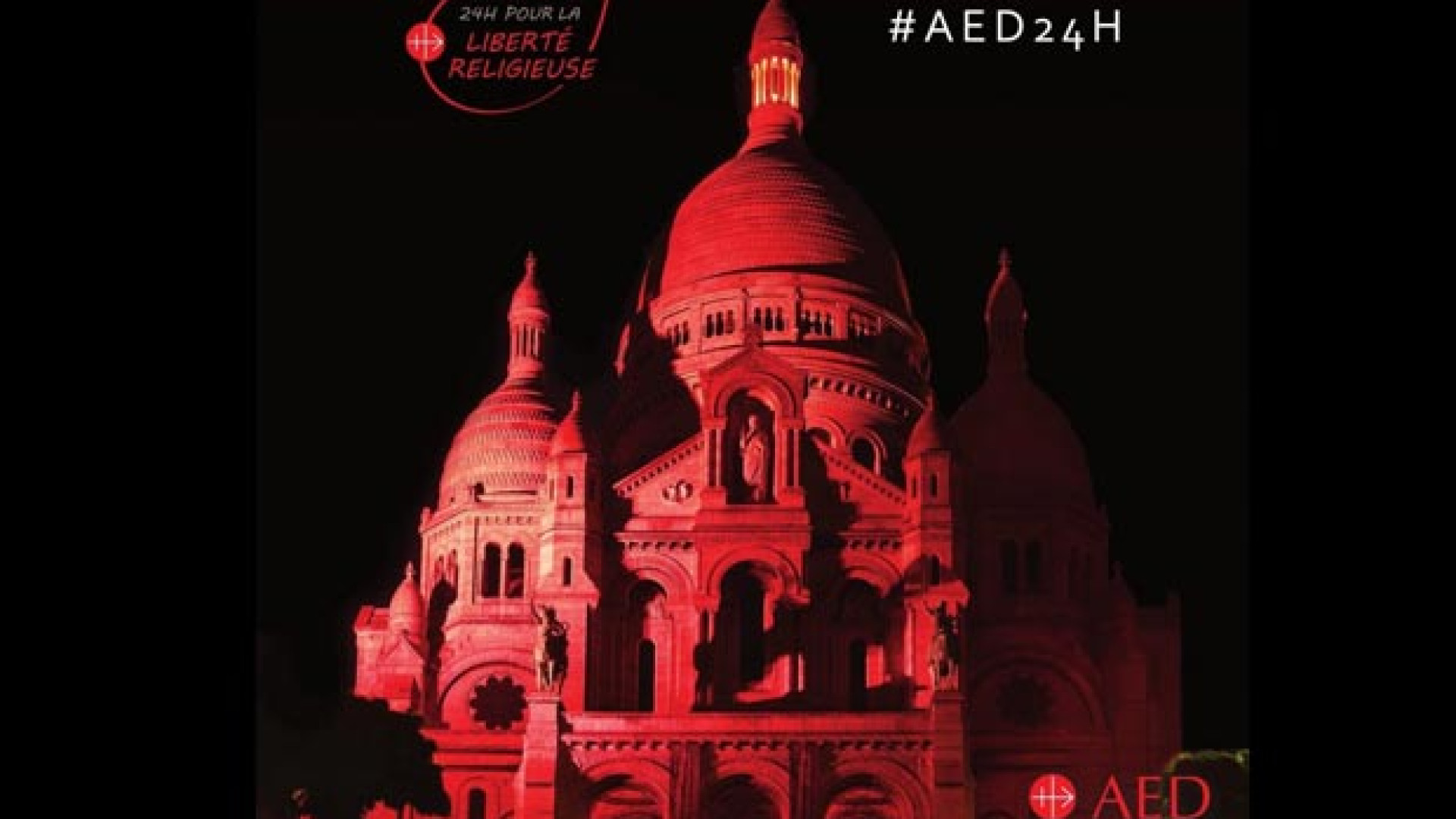Immagine di Martiri cristiani: la Basilica del Sacro Cuore a Montmartre illuminata di rosso