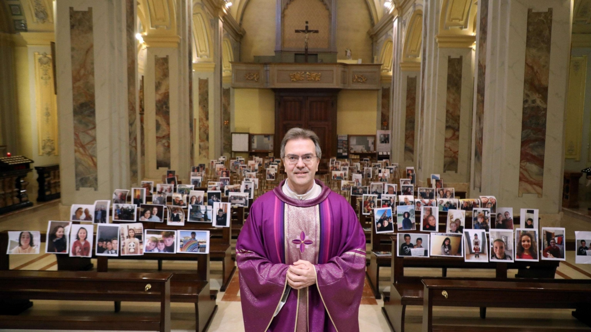 Immagine di Il parroco celebra Messa con le foto dei parrocchiani