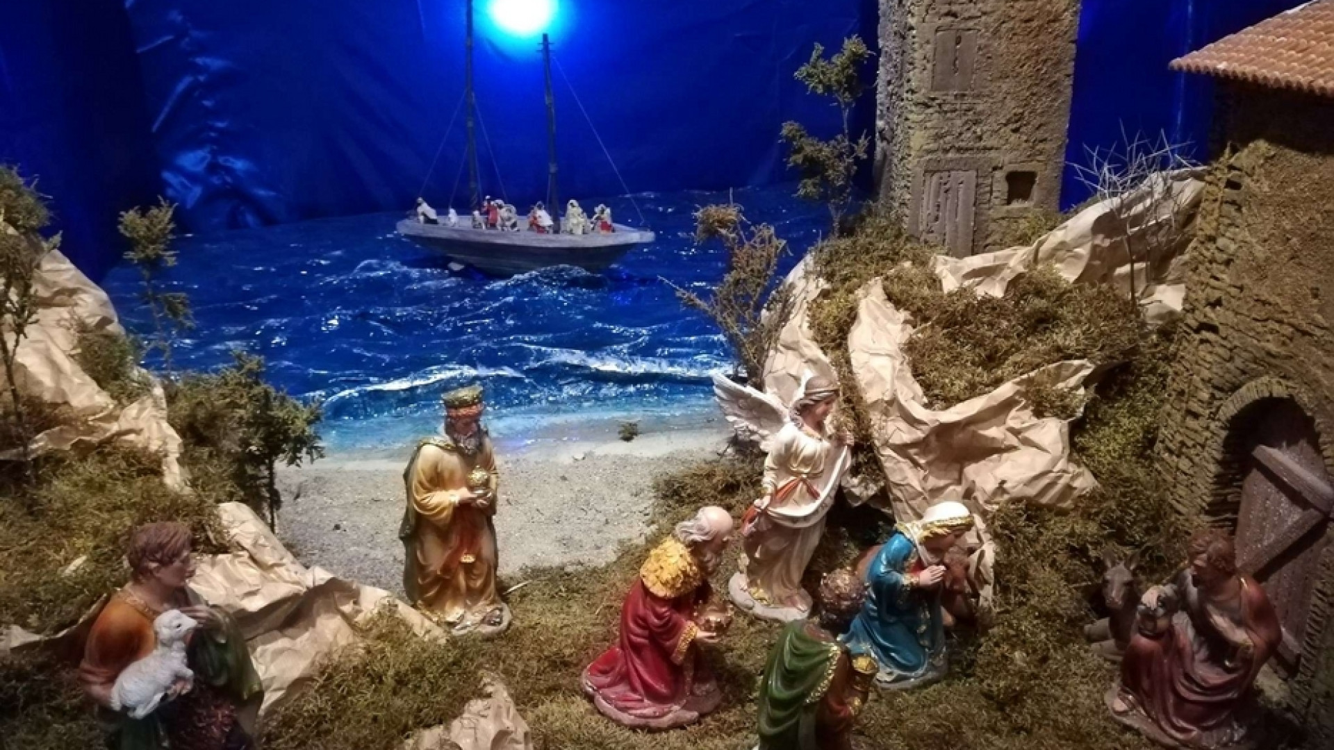 Immagine di Una piccola barca di persone migranti nel presepe della parrocchia