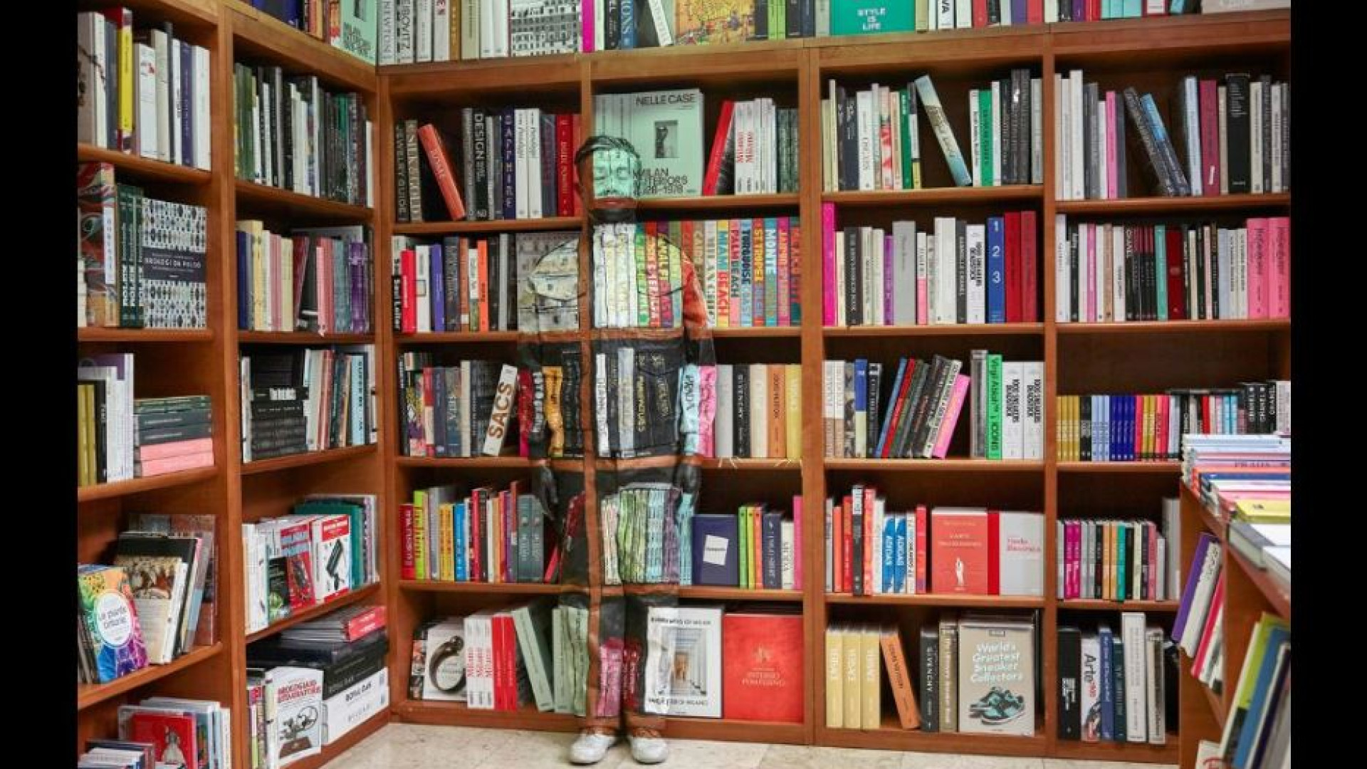 Immagine di Liu Bolin, ecco l'invisibile fra i libri della Hoepli