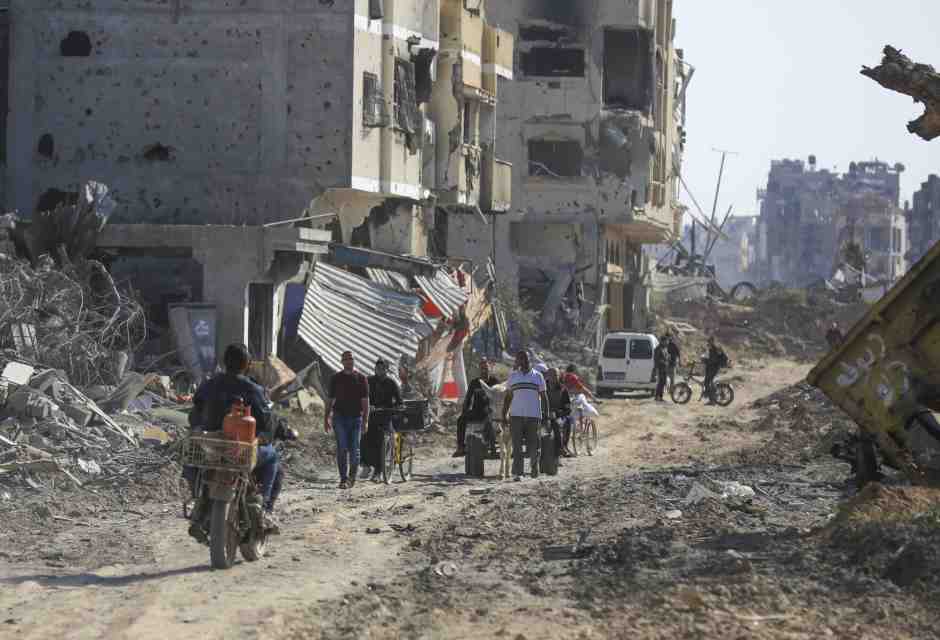 Palestinesi in mezzo alle macerie lasciate dall&rsquo;offensiva aerea e terrestre israeliana a Khan Younis (AP Photo/Ismael Abu Dayyah)&nbsp;<br />