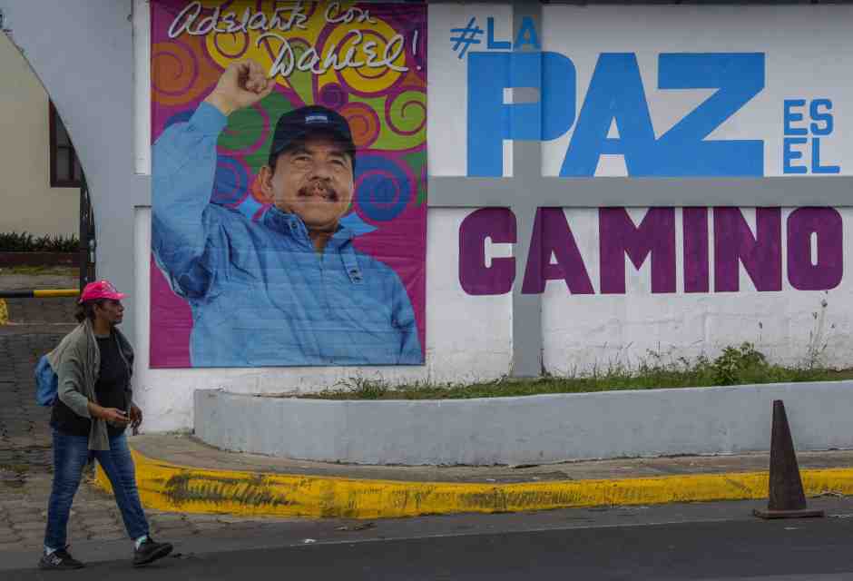 Una donna cammina davanti a un cartellone con una foto del presidente nicaraguense Daniel Ortega a Managua (Getty Images)&nbsp;<br />