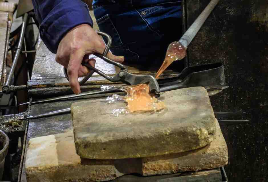 Un artigiano mentre lavora in una vetreria a Murano (Ansa) <br />