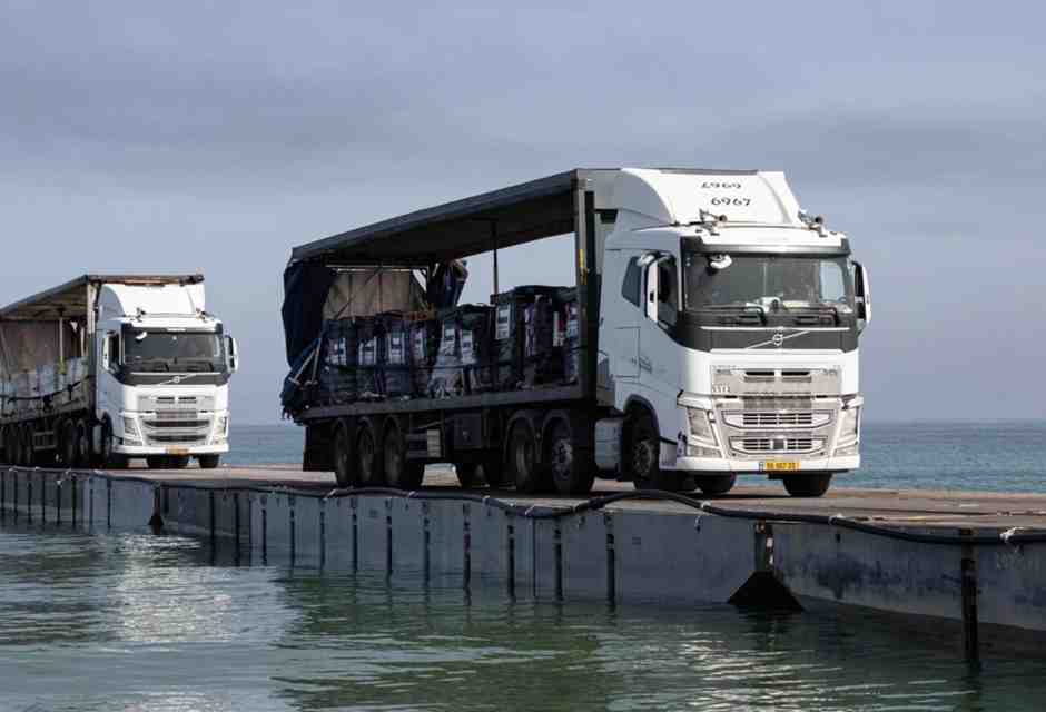 Alcuni camion attraversano il ponte galleggiante a Gaza (foto LaPresse)