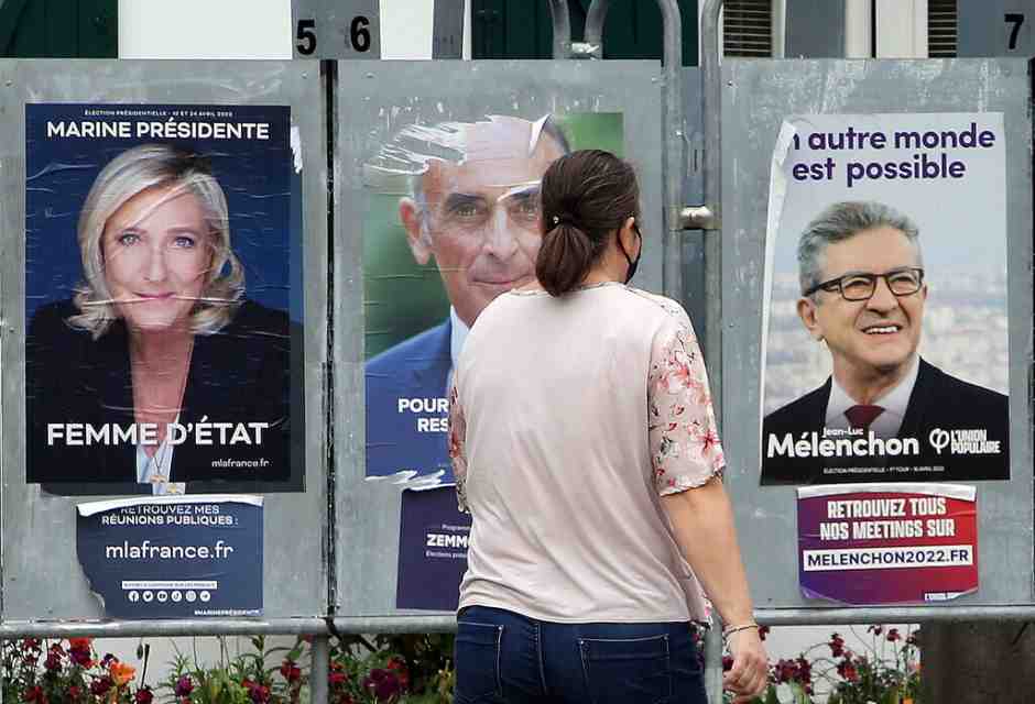 Una donna passa davanti ai manifesti della campagna elettorale (AP Photo/Bob Edme)&nbsp;<br />