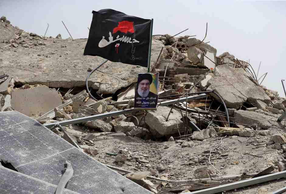Una foto del leader di Hezbollah Hassan Nasrallah tra le macerie di un edificio distrutto da un attacco israeliano nel sud del Liban (AP/Mohammad Zaatari)&nbsp;<br />