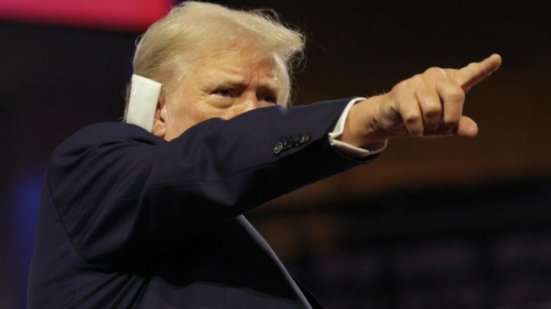 Immagine di Trump sul palco con l'orecchio fasciato celebrato come un eroe