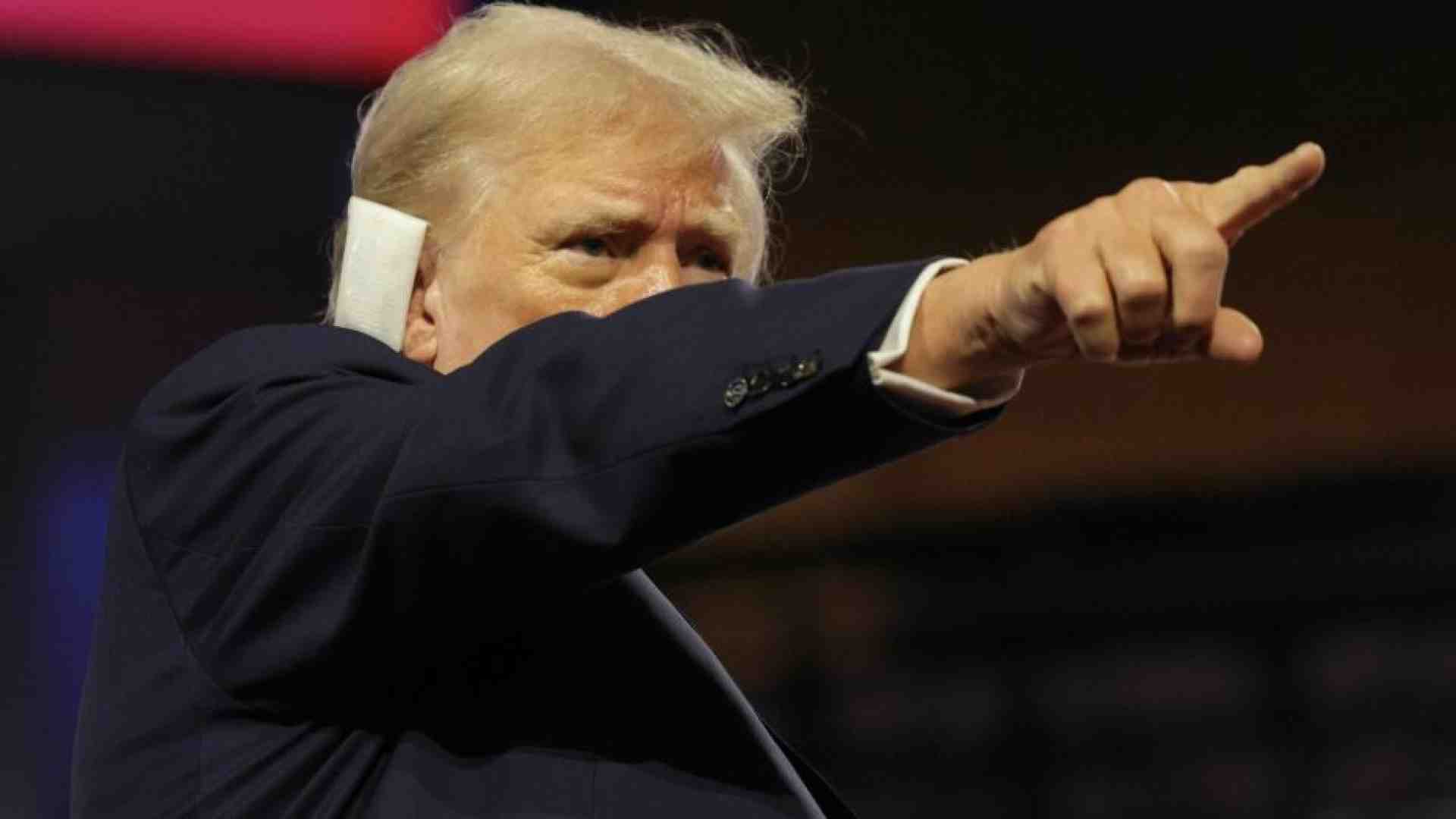Immagine di Trump sul palco con l'orecchio fasciato celebrato come un eroe