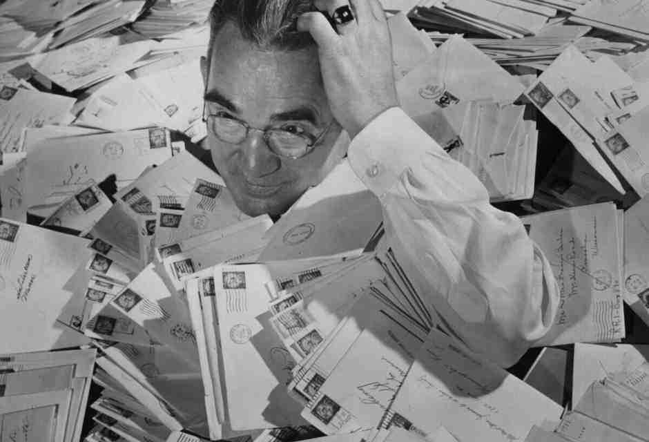 George Semanko, responsabile della sezione lettere morte dell’ufficio postale di Minneapolis, sepolto dalla corrispondenza di Natale del 1956 (foto Getty) <br />