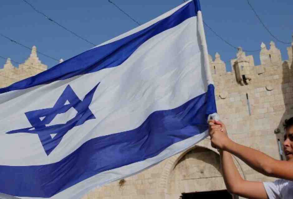 Un ragazzo sventola la bandiera di Israele a Gerusalemme (foto LaPresse)