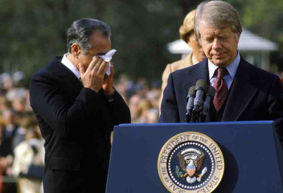 Il presidente Carter e lo shah Reza Pahlavi che si asciuga gli occhi per i fumi del gas usati in una manifestazione fuori dalla Casa Bianca (GettyImages)&nbsp;<br />