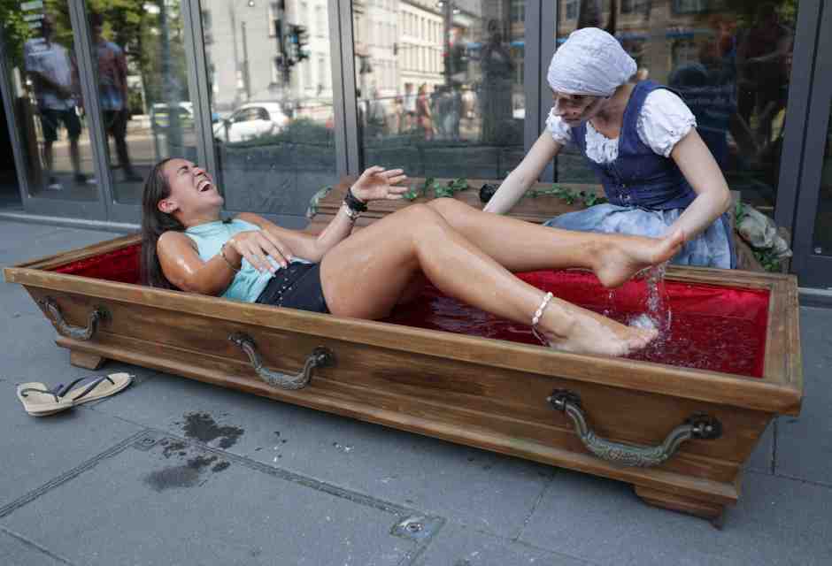 Una donna in una bara piena di acqua ghiaccio di fronte al Berlin Dungeon, attrazione a tema horror nella capitale tedesca (J&ouml;rg Carstensen/Getty Images)&nbsp;<br />