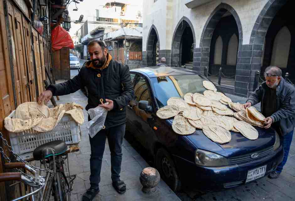 A Damasco due uomini stendono il pane appena sfornato (foto Getty)