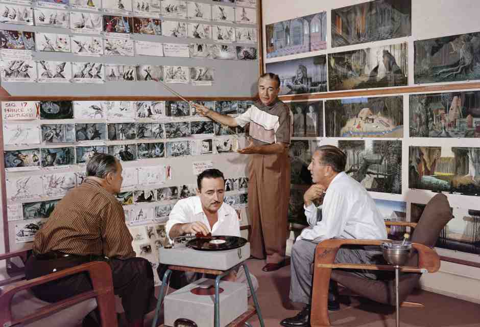 Walt Disney (a destra) ascolta un animatore parlare degli storyboard di “La bella addormentata” mentre Les Clark fa suonare un disco (Foto Getty)