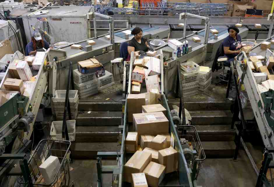 Addetti del servizio postale statunitense smistano i pacchi al Royal Palm Processing and Distribution Center di Opa Locka, Florida (Joe Raedle/Getty)&nbsp;<br />