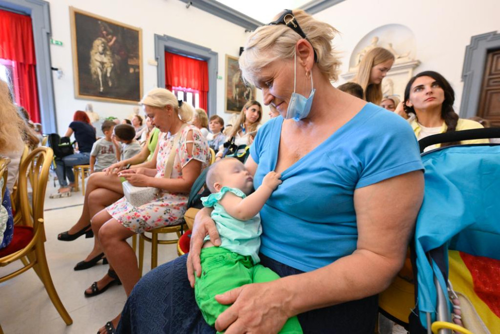 La signora Maria culla la nipotina nella Sala della Protomoteca - Foto Atlantia