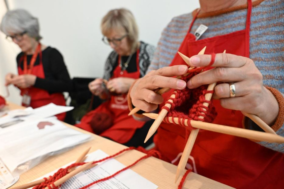 Volontarie di Emergency lavorano a maglia le Custodie per disinnesco, guanti con doppia apertura per mani che si stringono - ANSA