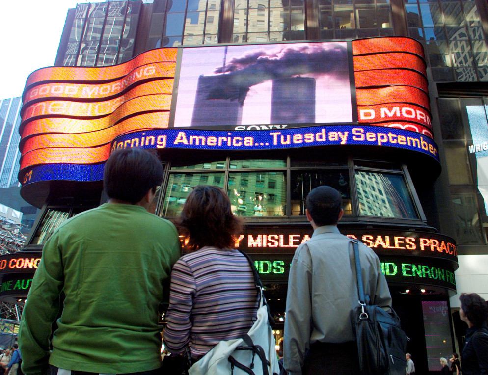 Le Twin Towers crollarono in diretta televisiva mondiale. I telegiornali di quei momenti riportano la voce scioccata dei giornalisti, le urla della gente che scappa, l’incredulità dei presenti. Su molti canali i programmi Tv vennero interrotti per dare la notizia. In Italia, ad esempio, molti bambini videro le immagini delle Torri perché una puntata della Melevisione venne improvvisamente interrotta per un’edizione speciale del Tg3. Nelle foto: persone che guardano in diretta le torri gemelle da Times Square l’11 settembre 2001.