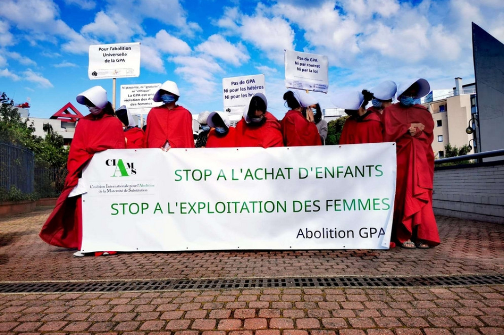 Un momento delle proteste davanti al Salone di Parigi: le attiviste della Coalizione per l’abolizione della maternità surrogata vestite in rosso come "ancelle" - Foto Cappelletti