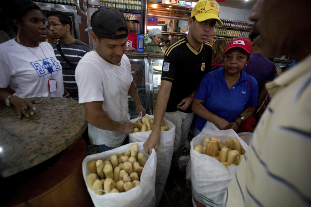 Distribuzione del pane ai poveri (Ansa/Ap)