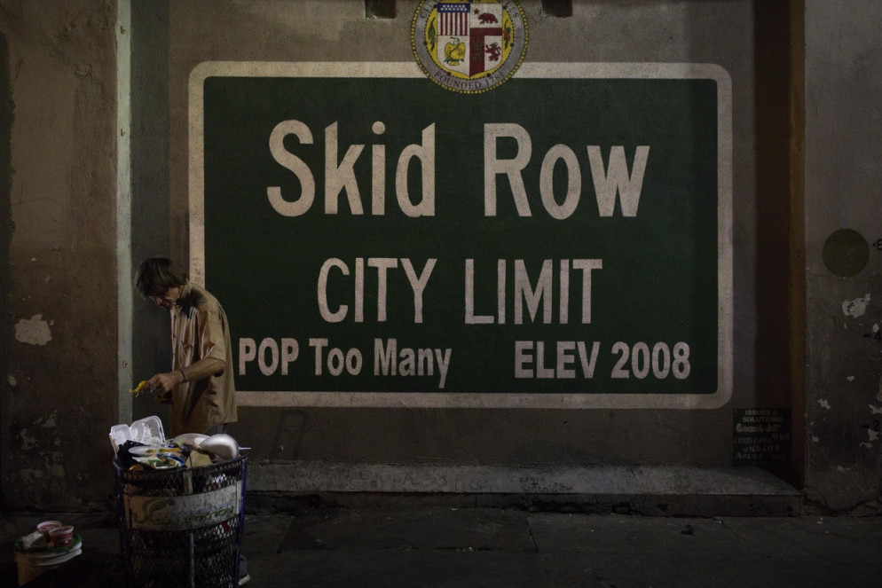 Un senzatetto in cerca di cibo da un cassonetto della spazzatura nella zona Skid Row di Los Angeles: nella metropoli il numero di homeless è cresciuto del 26 per cento (Ansa)