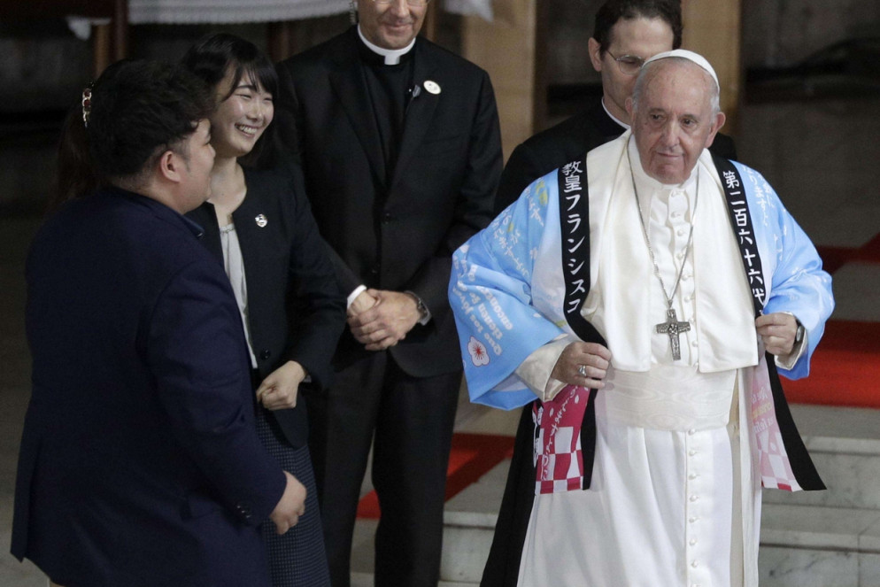 Francesco indossa la camicia che i giovani gli hanno donato (Ansa)