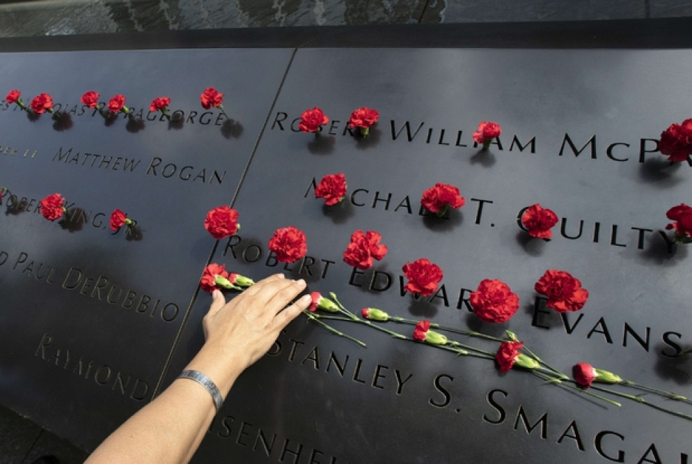Norma Molina, di San Antonio, Texas, depone fiori sotto la lista dei pompieri del reparto Engine 33 al memoriale dell'11 settembre a New York City. Il suo fidanzato morì con loro 8Ap)