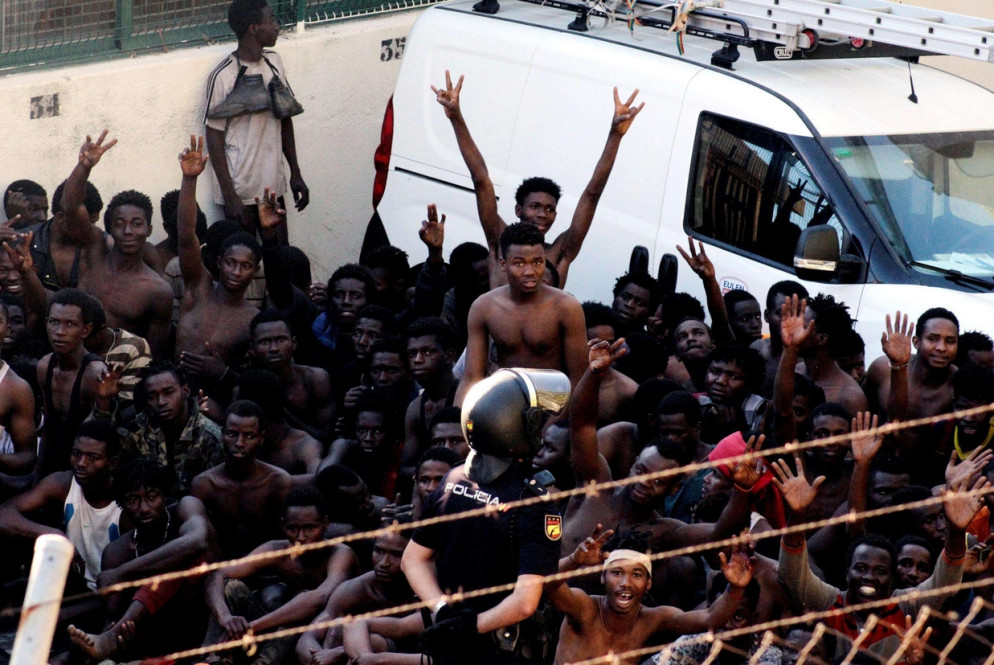 Il gesto di vittoria di chi è riuscito a superare la recinzione ed entrare a Ceuta (Ansa)