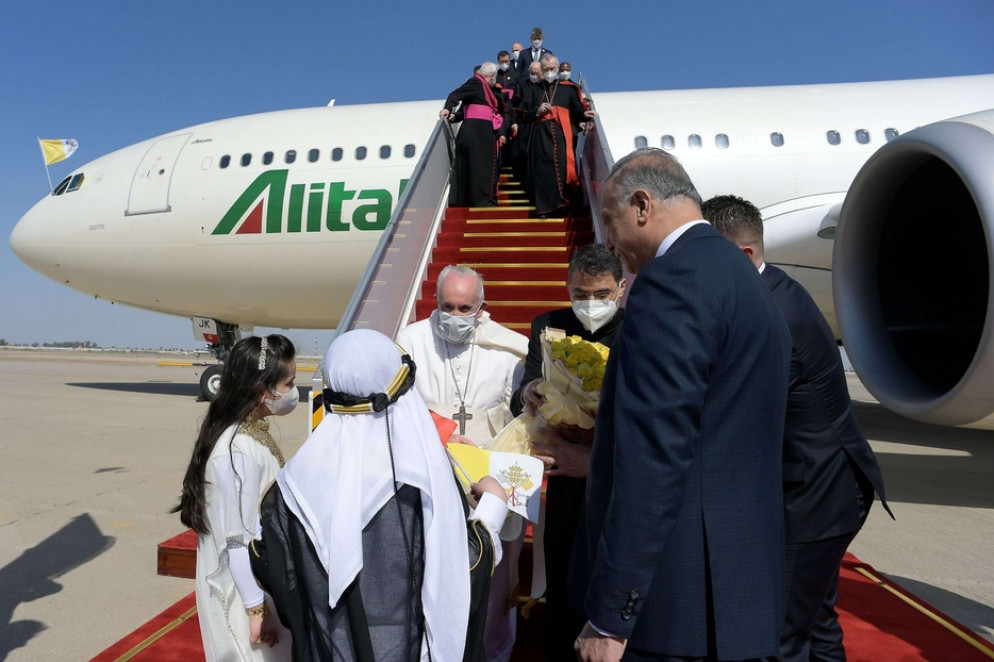 Due bambini in abito tradizionale hanno consegnato un omaggio floreale al Papa, una volta atterratto all'aeroporto di Baghdad - Reuters