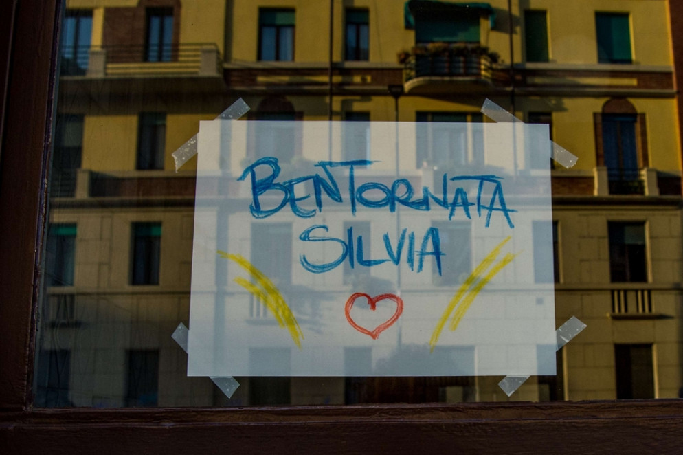 Un cartello di benvenuto sul portone dell'abitazione di Silvia Romano, a Milano - Fotogramma