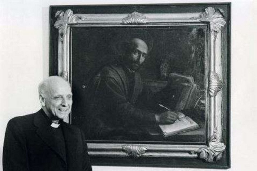 Padre Arrupe all'interno della Curia dei gesuiti a Roma ritratto accanto a un quadro raffigurante Ignazio di Loyola