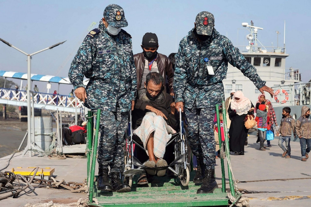 Un anziano invalido aiutato a imbarcarsi nel porto di Chittagong - Ansa