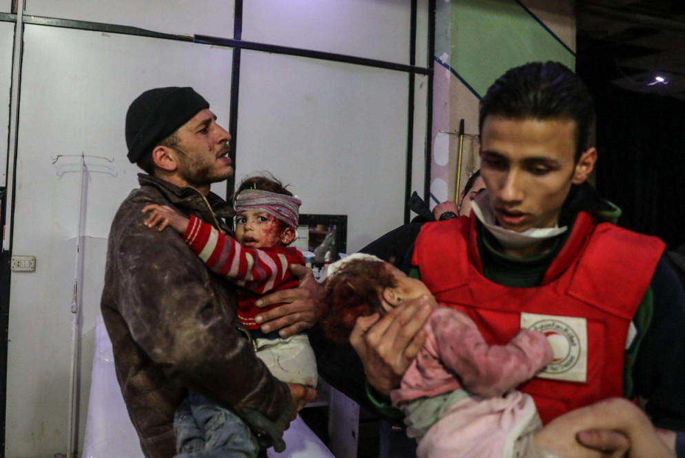 Foto rilasciata dal gruppo anti-governativo siriano Ghouta Media Center, mostra due bambini siriani feriti durante gli attacchi aerei a Ghouta, alla periferia di Damasco (Ansa)