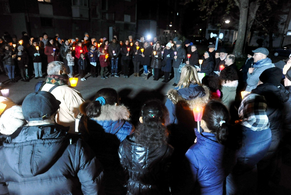 In cerchio, nel cortile di via del Danubio: un abbraccio di voci oranti e di luce (Fotogramma)