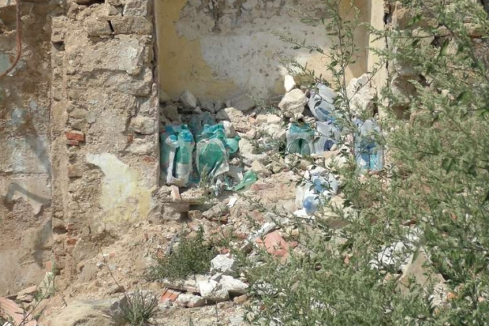 A sinistra, bottiglie d’acqua ancora oggi accatastate in una nicchia di quel che resta d’un negozio di alimentari ad Accumoli