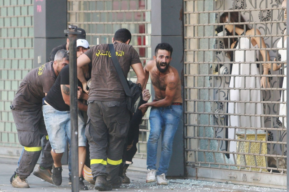 Beirut. Un ferito viene portato via dal luogo della sparatoria - Reuters