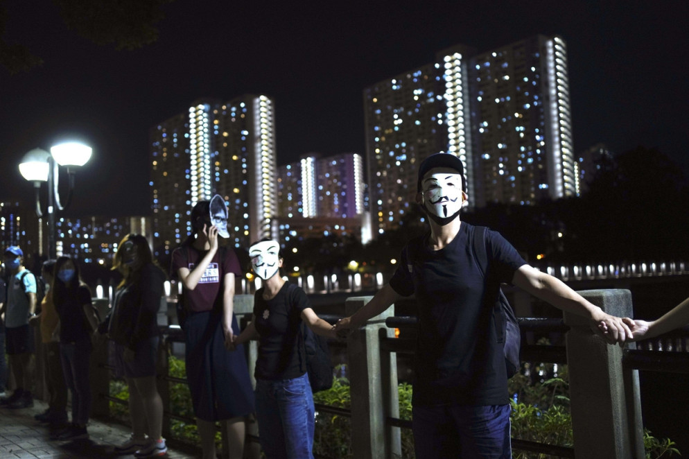 Una catena umana notturna nel cuore economico di Hong Kong (Ansa)