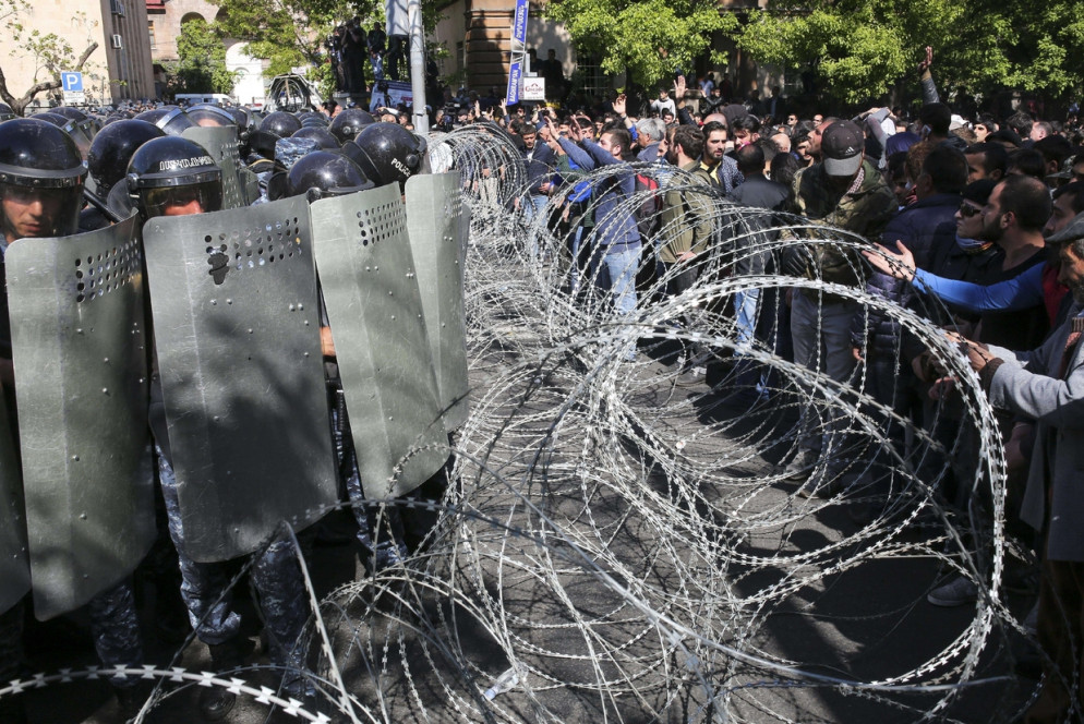 La polizia ferma i dimostranti che vogliono impedire l'accesso dei deputati al Parlamento (Ansa)