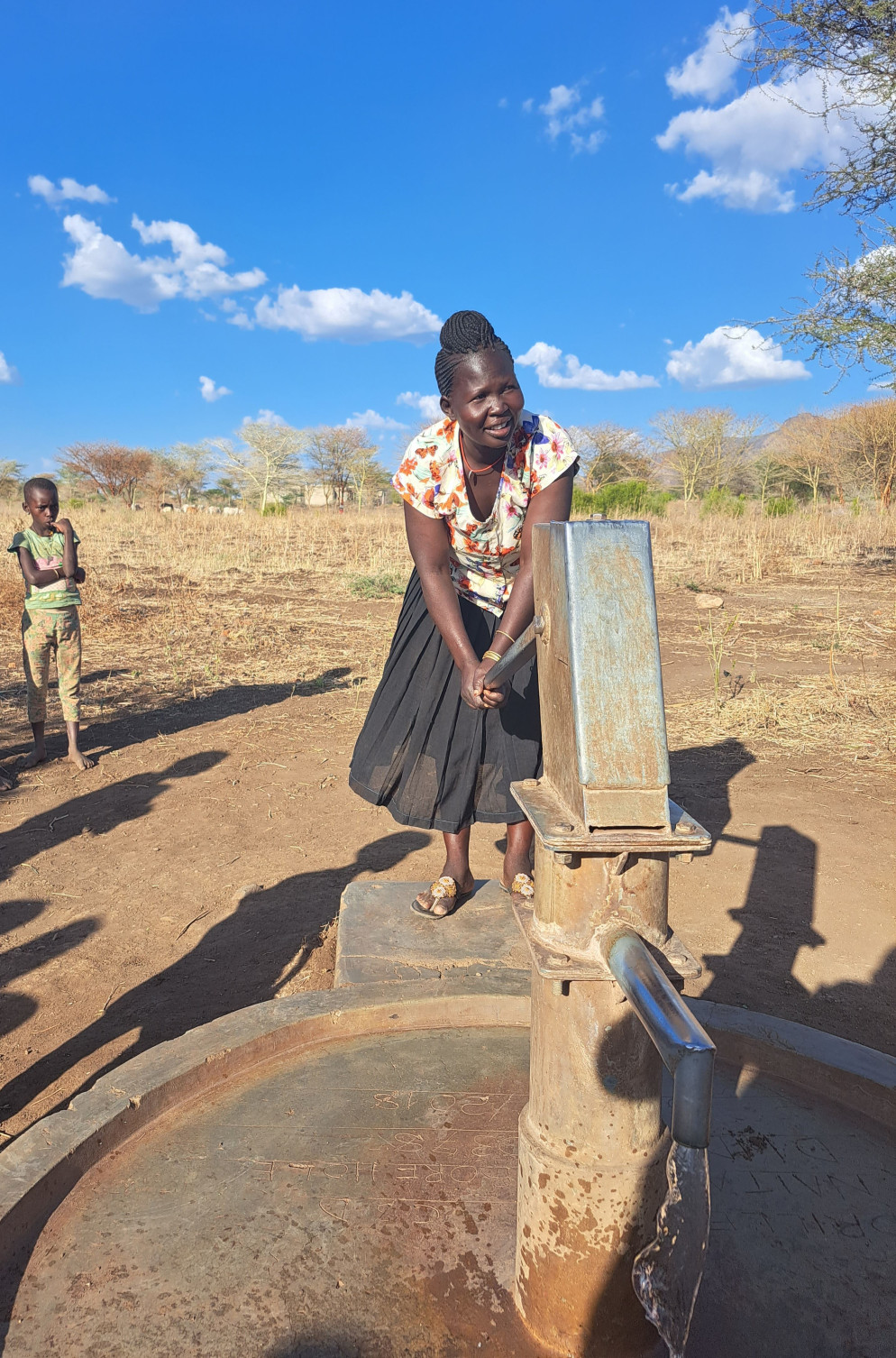 Christine Napeyok prende l’acqua dal pozzo realizzato vicino casa sua da Africa Mission - Alfieri