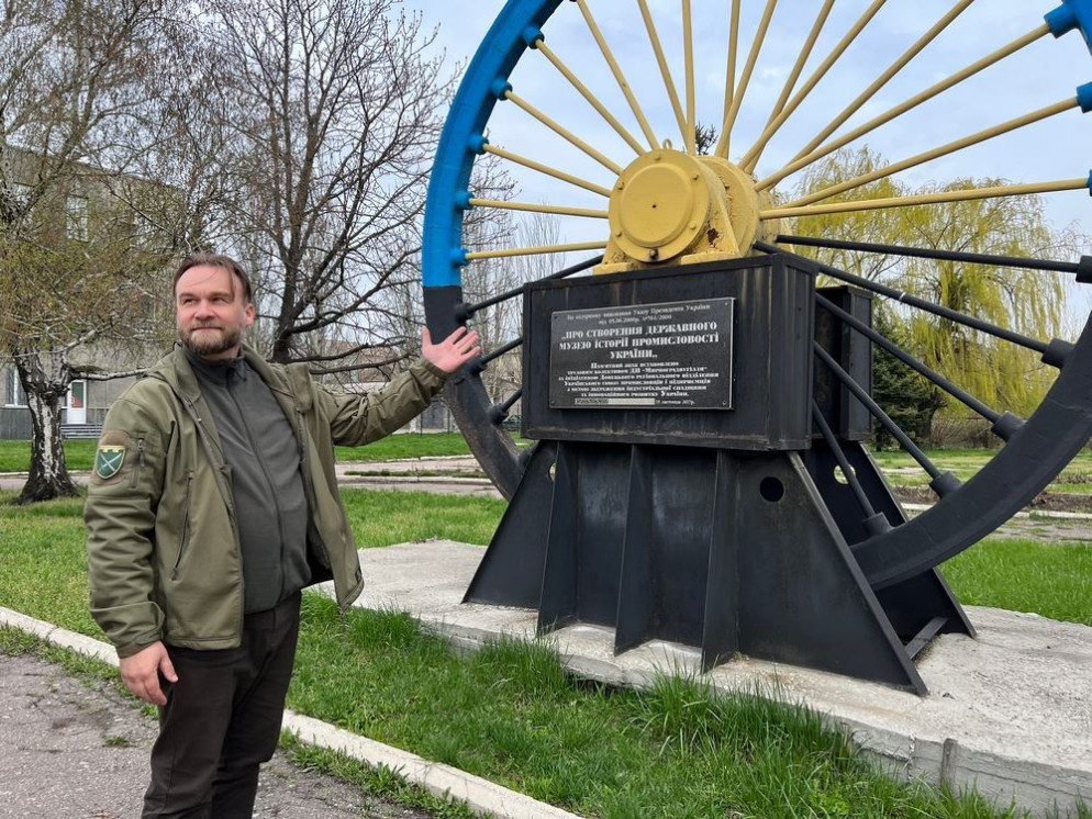 Padre Ivan Vasylenko davanti al simbolo della città di Myrnohrad - Gambassi