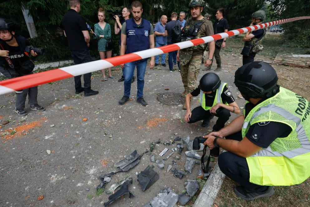La polizia ucraina mentre raccoglie i resti di un missile russo caduto a Kiev - Ansa