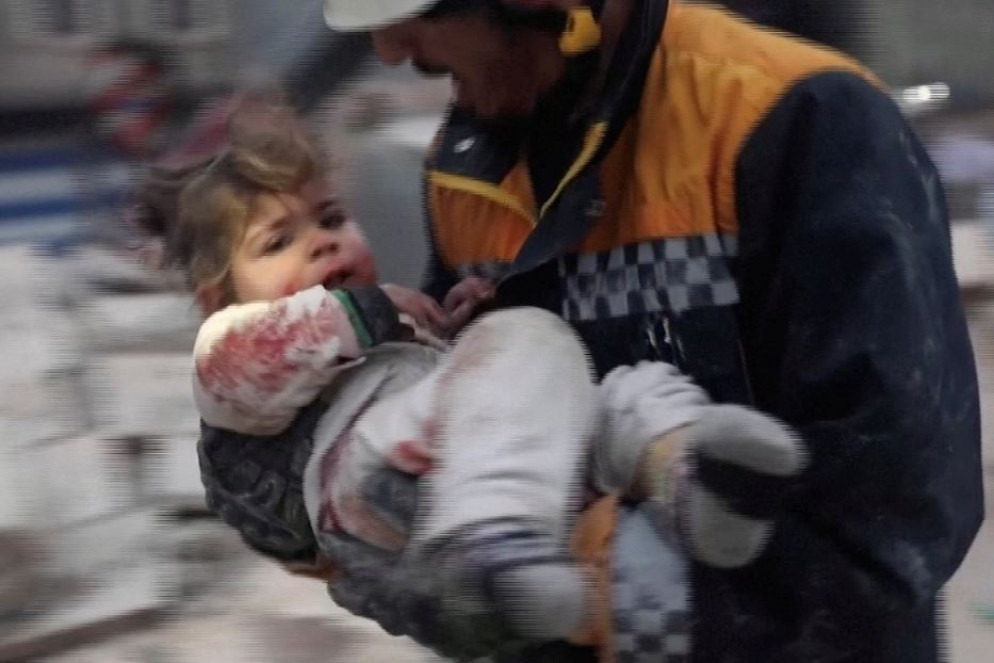 Un soccorritore con un bimbo in braccio nella cittadina siriana di Azaz controllata dai ribelli - Reuters /fermo immagine da video