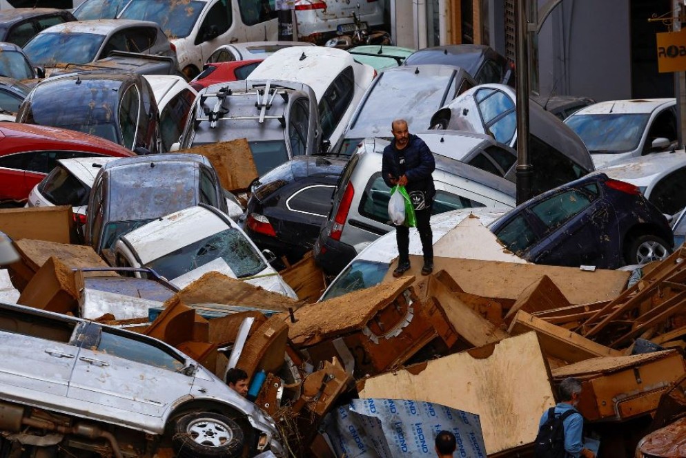 Le persone si muovono stralunate tra pile di automobili per le strade di Valencia - Reuters