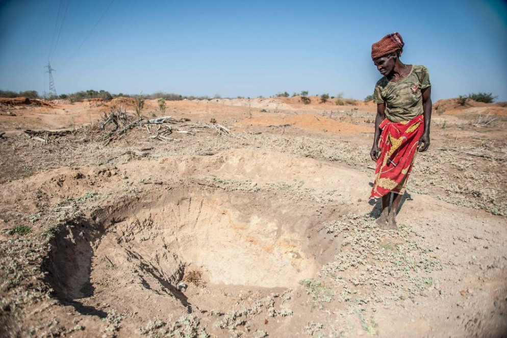 Adelaide Maphangane davanti a una pozza vuota nel distretto di Mabalane, in Mozambico (CC, Aurélie Marrier d'Unienville / IFRC) - undefined
