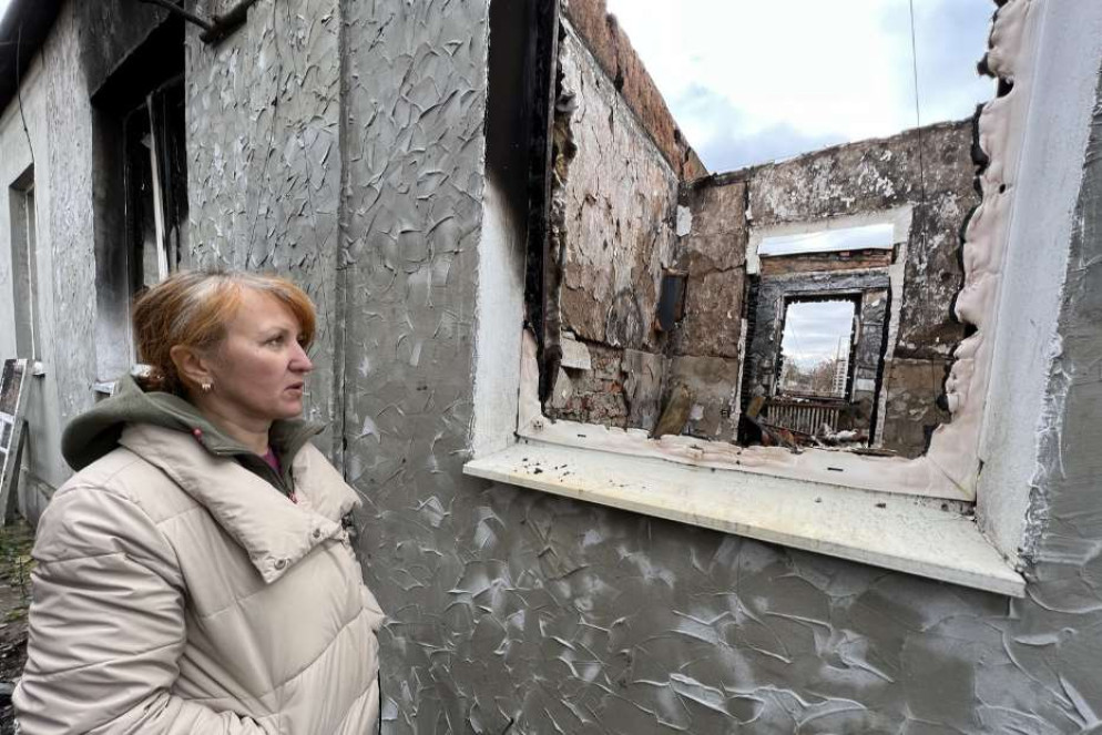 Svetlana di fronte a una casa distrutta a Slatyne - Gambassi