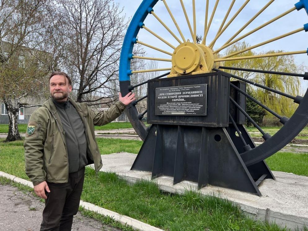 Padre Ivan Vasylenko davanti al simbolo della città di Myrnohrad - Gambassi