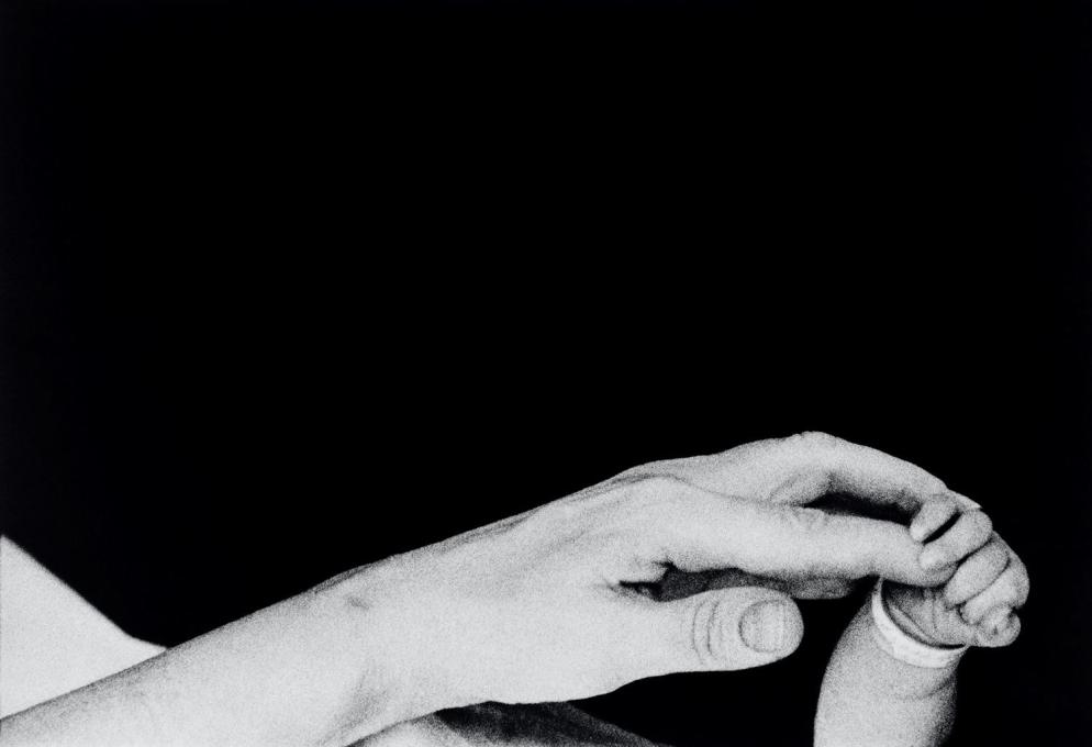 In mostra a Forlì, Musei di San Domenico, "Eve Arnold. L’opera, 1950-1980": i primi cinque minuti di vita di un neonato. Una madre tiene la mano del suo piccolo. New York, Long Island, 1959 - © Eve Arnold / Magnum Photos