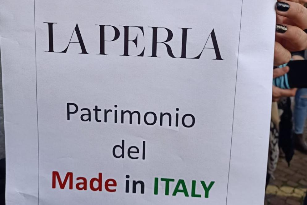 Uno dei cartelli di protesta esposto davanti allo stabilimento de La Perla a Bologna