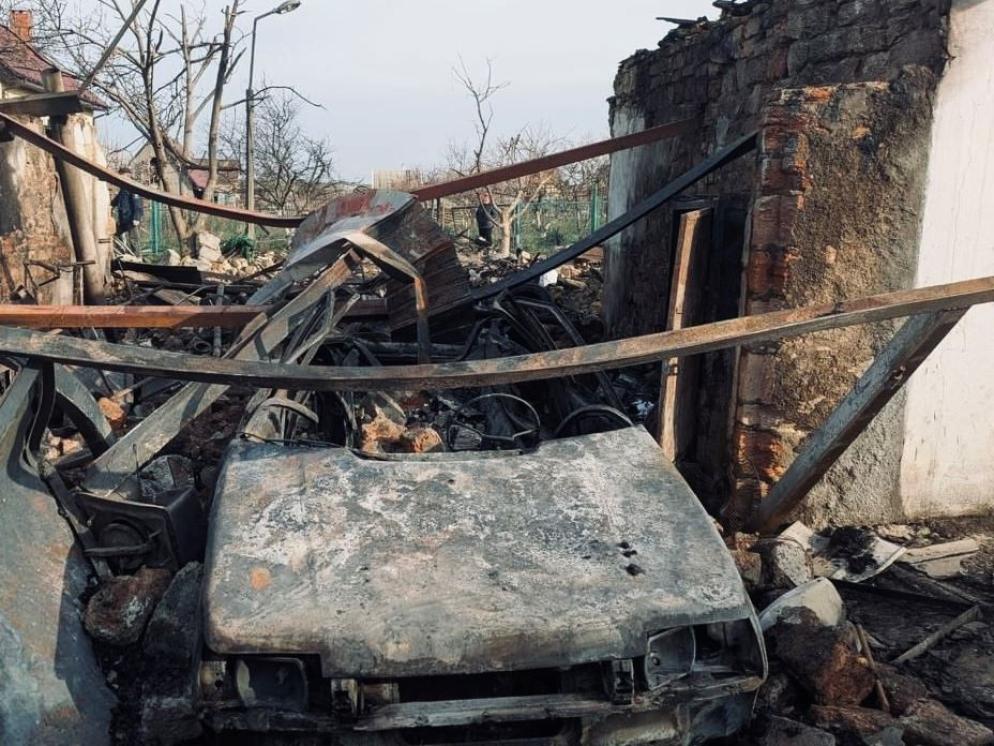 Un’auto distrutta dall’esplosione che ha devastato anche le abitazioni. I residenti erano corsi al riparo poco prima che i droni colpissero le loro case