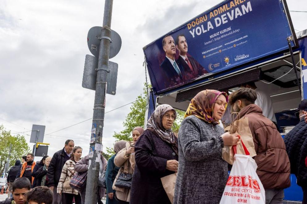 Persone in fila per ricevere gratuitamente un panino e dell’acqua distribuiti da un camper della campagna elettorale del presidente Tayyip Erdogan in vista delle elezioni del 14 maggio - Reuters